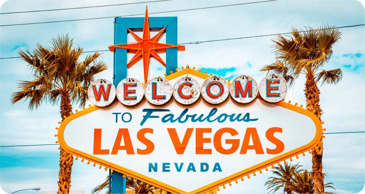 a sign in front of a palm tree with Welcome to Fabulous Las Vegas sign in the background