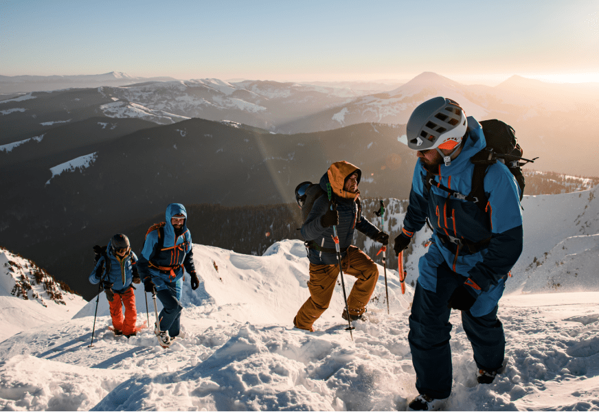a group of people standing on top of a snow covered mountain