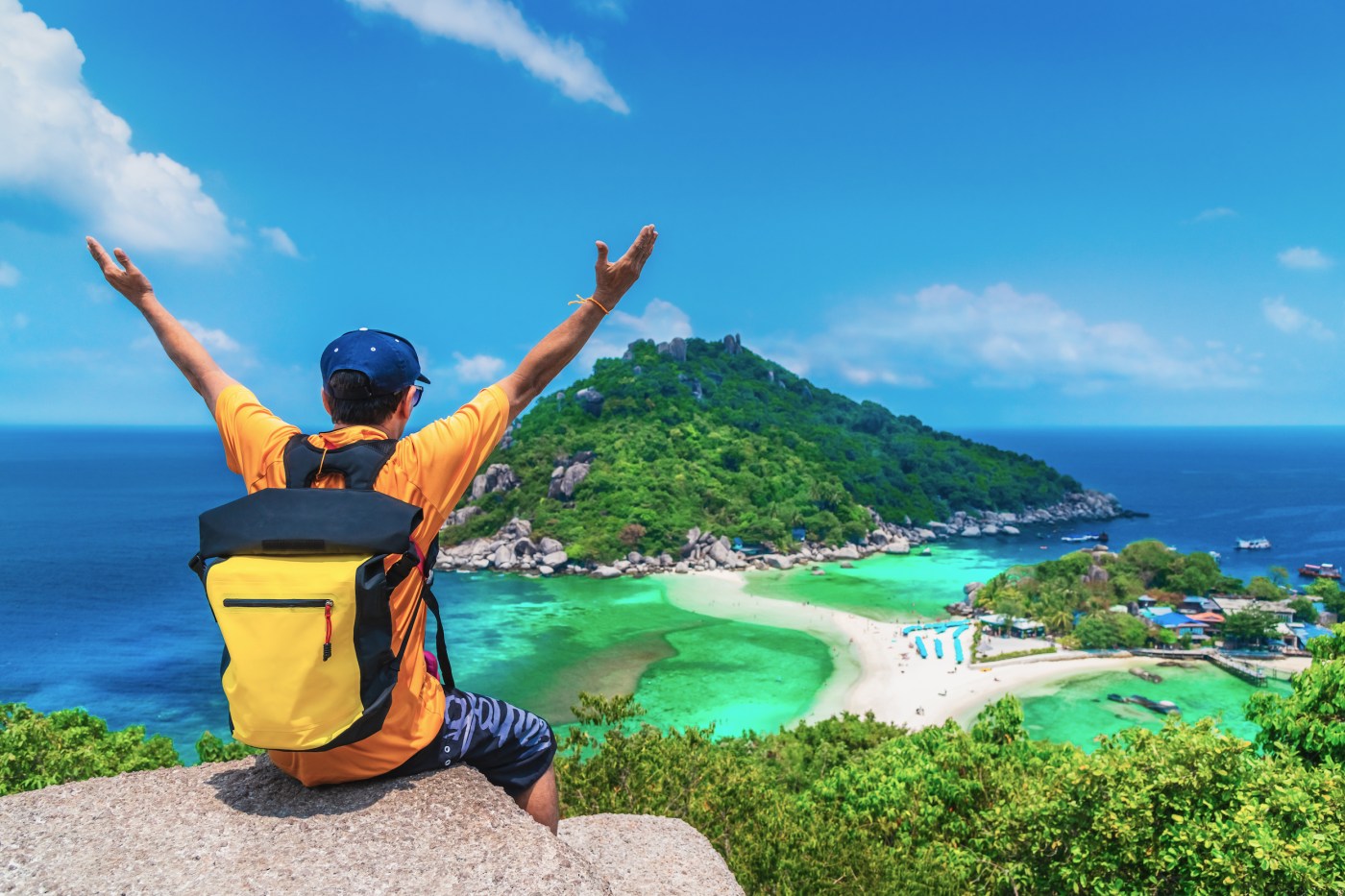 a man sitting on a beach near a body of water